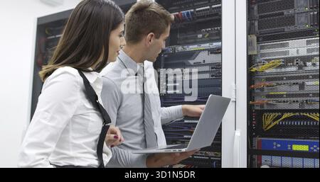Technicians using laptop while analyzing server in server room Stock Photo