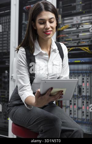 Technician using tablet pc while analysing server in large data center Stock Photo