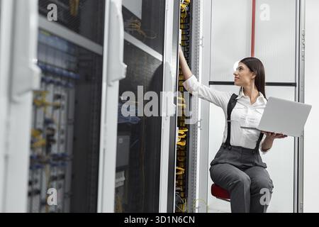 Technicians using laptop while analyzing server in server room Stock Photo
