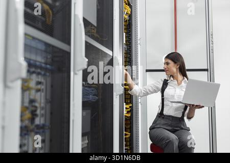 Technician examining server in server room Stock Photo