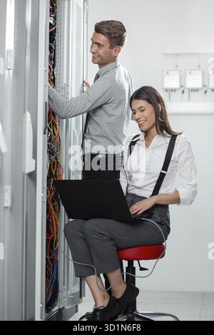 Team of technicians working together on servers at the data centre Stock Photo