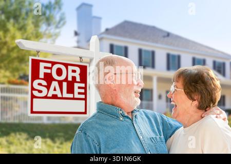 Happy Senior Couple Front of For Sale Real Estate Sign and House Stock ...