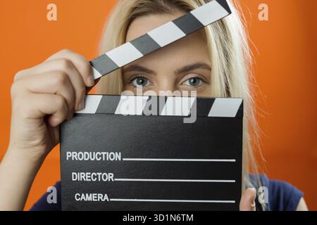 Young woman in action, holding clapperboard. Cinema concept Stock Photo