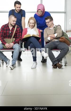 Group of young students collaborating on project in library Stock Photo