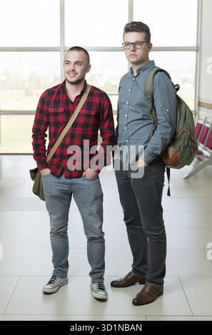 Smiling handsome students posing in a corridor Stock Photo