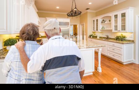 Senior Couple Looking Over Beautiful Custom Kitchen Stock Photo