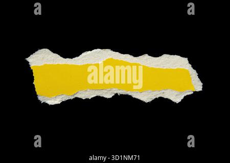 Ripped yellow paper torn edges isolated on black background, paper tear Stock Photo