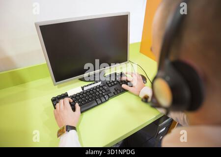 Rear view of a young man working of a computer Stock Photo