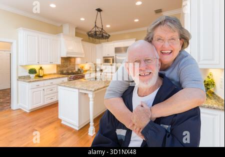 Senior Couple Hugging Inside Custom Kitchen Stock Photo