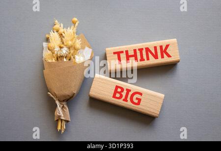 Think big symbol. Wooden blocks with words Think big. Beautiful grey background. Business and Think big concept. Copy space. Stock Photo