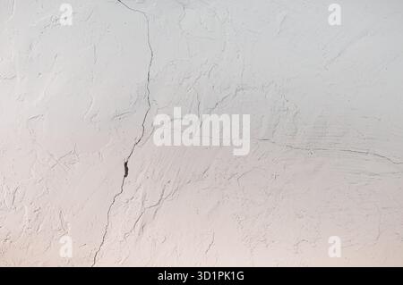 White Plastered Wall with Cracks - background or texture Stock Photo