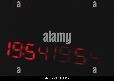 Blurred red magical 19:54 grainy texture light effect on black background Stock Photo