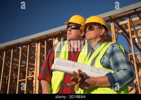 Male and Female Construction Workers at Construction Site Stock Photo