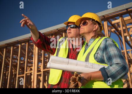 Male and Female Construction Workers at Construction Site Stock Photo