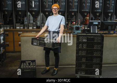Male worker or business owner uploads packages of coffee on factory or warehouse, barista in coffee shop Stock Photo