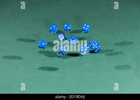 Ten blue dices falling on a green table Stock Photo