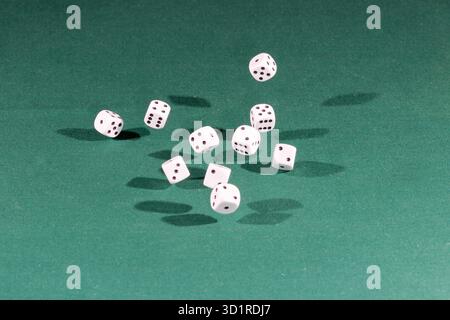 Ten white dices falling on a green table Stock Photo