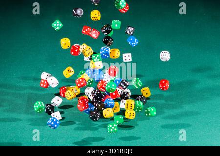 Hundred colored dices falling on a green table Stock Photo