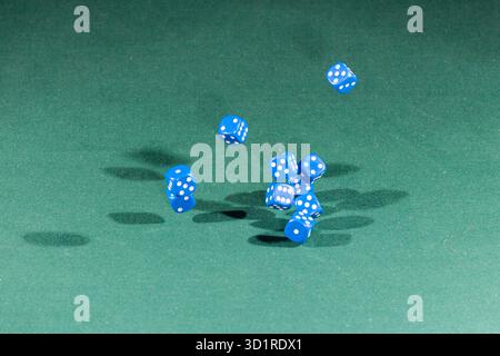 Ten blue dices falling on a green table Stock Photo