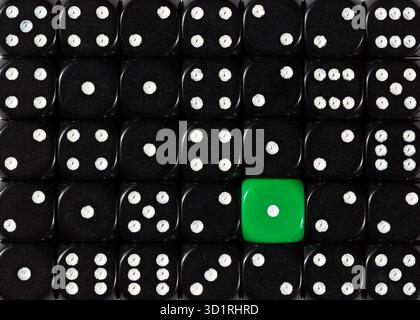 Background of random ordered black dices with one green cube Stock Photo