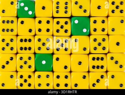 Background of random ordered yellow dices with three green cubes Stock Photo