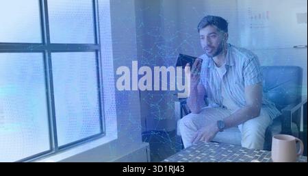 Indian man in striped shirt speaking into smartphone by lounge window with whiteboard, copy space Stock Photo