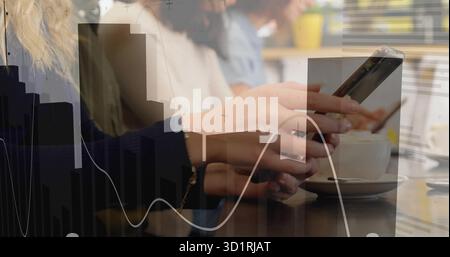 Holding smartphone between hands over wooden cafe table with cup, showing colleagues analyzing data Stock Photo