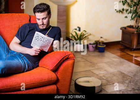 Young man sitting doing a crossword puzzle Stock Photo