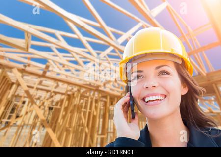 Female Contractor In Hard Hat Using Cell Phone At Construction Site Stock Photo