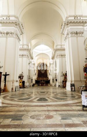 Catania, Sizilien - Italy - 04-15-2025: Interior of the Cathedral of SantAgata in Catania with high vaulted arches, ornate altar, white walls and patt Stock Photo