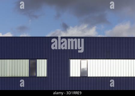 Blue corrugated iron facade with windows, blue sky, graphic, warehouse, logistics hall Stock Photo