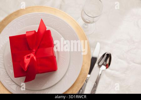 Christmas Gift with Place Setting at Table Stock Photo