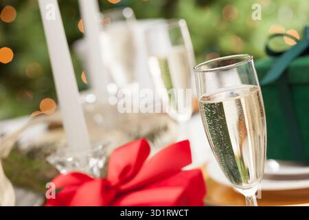 Champagne Glass and Christmas Gift with Place Setting Abstract at Table Stock Photo
