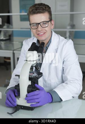 Scientist looking through a microscope in a laboratory Stock Photo