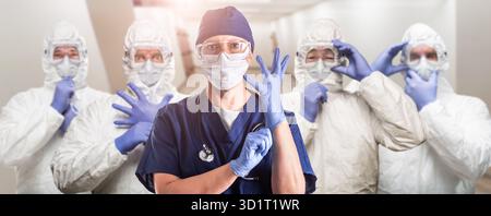 Team of Female and Male Doctors or Nurses Wearing Personal Protective Equiment In Hospital Hallway Stock Photo