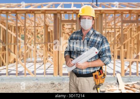 Male Contractor In Hard Hat Wearing Medical Face Mask During Coronavirus Pandemic At Construction Site Stock Photo