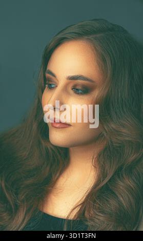 Studio portrait of a brunette woman with blue eyes and flawless complexion, makeup transformation revealing confident and graceful beauty Stock Photo