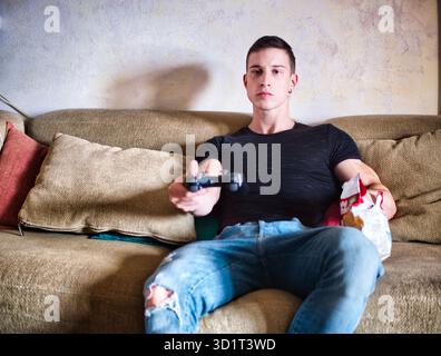Attractive guy playing videogames with joystick in hand Stock Photo