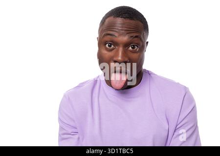 Young charismatic 30 year old american guy dressed in a cotton t-shirt grimacing on a white background Stock Photo