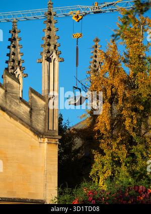 Giant crane looming over the spires of All Souls College.   All Souls College was founded by Henry VI of England and the Archbishop of Canterbury, in 1438.  Here we its ornate spires, viewed from New College Lane. The 21st century makes an appearance with a giant crane from a nearby construction site. Stock Photo
