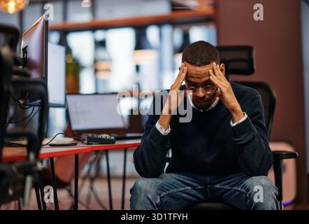 Exhausted African American Programmer Resting at Work. Stock Photo