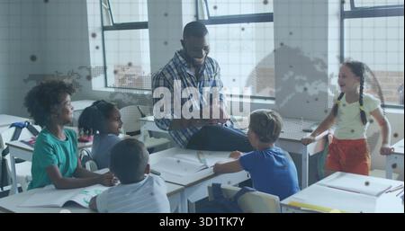 Guiding teacher in plaid shirt directing student discussion in classroom, with notebooks, backpacks Stock Photo