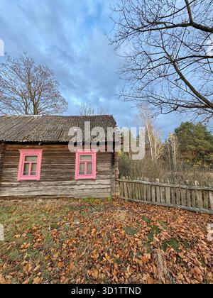 A dilapidated log house on the edge of the forest. Autumn landscape. Stock Photo