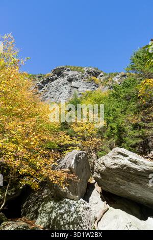 Beautiful photo of the rocks and the colorful trees in autumn in Smugglers Notch in Vermont. Stock Photo