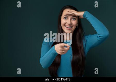 Woman With Long Black Hair Holding Hands Up to Face Stock Photo