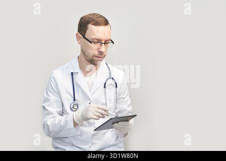 Doctor using tablet. Hospital electronic device. Online patient examination Stock Photo