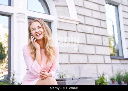 Pretty young woman talking by phone. Happy female person Stock Photo
