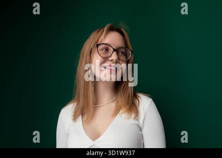 Woman Wearing Glasses Standing in Front of Green Wall Stock Photo