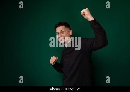 Man in Black Shirt Raises Fist Stock Photo