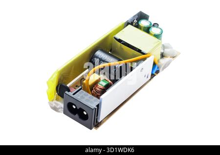 Close-up of an old damaged power supply circuit board showing a swollen capacitor and other electronic parts. Suitable for repair, electronics, and te Stock Photo